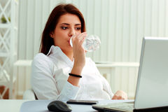 mulher-de-negócios-nova-bebe-água-em-seu-local-de-trabalho-35695766